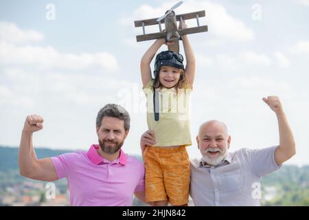 Loisirs en famille actifs avec les enfants.Garçon fils avec père et grand-père avec un avion jouet joue sur fond de ciel d'été. Banque D'Images