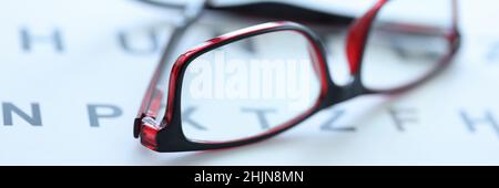 Des lunettes élégantes aux cadres noir et rouge se trouvent sur une table de près ophtalmique Banque D'Images