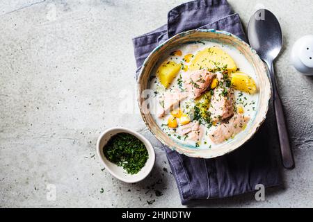 Soupe de poisson norvégien avec truite, pommes de terre et maïs, fond gris, vue de dessus, espace copie.Soupe de saumon et de pommes de terre. Banque D'Images