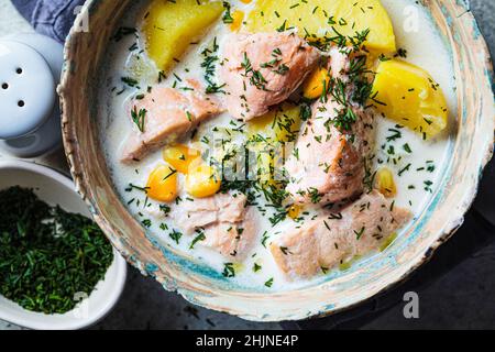 Soupe de poisson norvégien avec truite, pommes de terre et maïs, fond gris, vue de dessus, gros plan.Soupe de saumon et de pommes de terre. Banque D'Images