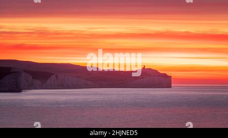 Lever de soleil coloré en janvier depuis le bord de la falaise de Seaford Head, en regardant vers le phare Seven Sisters et Belle Tout sur la côte est du Sussex Banque D'Images