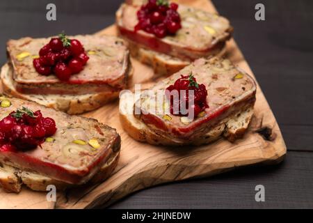 Terrine française traditionnelle en tranches recouverte de bacon sur fond de bois sombre Banque D'Images