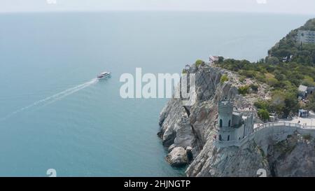 Vue de dessus du château sur le bord de la falaise raide.Action.Le magnifique château blanc est situé au-dessus de la falaise rocheuse près de la mer bleue.Château de Iglue's Nest sur la rive i. Banque D'Images