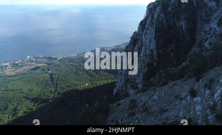 Vue aérienne de l'ascenseur jaune se déplaçant sur le téléphérique près de la pente de haute montagne couverte d'arbres et d'arbustes.Magnifique station d'été Banque D'Images