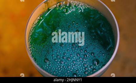 Gros plan d'une magnifique boisson gazeuse en verre transparent.Films.Boisson colorée luxueuse avec bulles en surface et spa irisé Banque D'Images