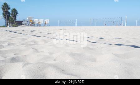 Joueurs jouant au volley-ball sur la plage, jeu de volley-ball avec balle et filet, côte de Californie, États-Unis.Des personnes actives défocacées sur le terrain de sport, sur la rive sablonneuse de l'océan.Arrière-plan cinemagraph en boucle sans couture. Banque D'Images