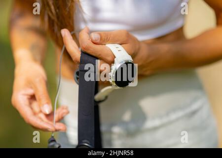 Gros plan d'une femme utilisant une montre de sport intelligente et un moniteur de fréquence cardiaque avec ceinture thoracique pendant l'entraînement Banque D'Images