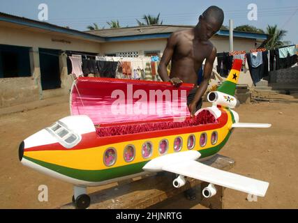 LES INNOVATIONS DU 21ST SIÈCLE ONT MÊME ENVAHI LES CERCUEILS EXTRAVAGANTS TRADITIONNELS DE LA TRIBU GA AU GHANA EN AFRIQUE DE L'OUEST.PENDANT DES DÉCENNIES, LA TRIBU DES GA A ENTERRÉ LEURS PROCHES DANS DES CERCUEILS QUI CORRESPONDENT À LEUR COMMERCE OU À LEUR STATUT COMME UN POISSON GÉANT POUR UN PÊCHEUR.CEPENDANT, AVEC LES PROGRÈS EN MARCHE, LES COFFINS SONT MAINTENANT PRODUITS DANS DES STYLES MODERNES TELS QUE LES BOUTEILLES DE COKE, LES APPAREILS PHOTO, LES BASKETS NIKE, LES AVIONS À RÉACTION ET LES BIROS EN PLASTIQUE.L'IMAGE MONTRE LE CERCUEIL D'AVION UTILISÉ PAR CEUX QUI TRAVAILLENT OU VOYAGENT DANS L'INDUSTRIE, ET LEURS FAMILLES.PHOTO : GARYROBERTSPHOTO.COM Banque D'Images