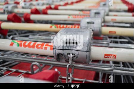 Moscou, Russie, juin 2020 : gros plan d'un récepteur à pièces sur les poignées des chariots Auchan avec serrures. Banque D'Images