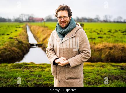 Meggerdorf, Allemagne.31st janvier 2022.Jan Philipp Albrecht (Bündnis90/Die Grünen), ministre de l'environnement du Schleswig-Holstein, se trouve devant un fossé d'eau de réception devant une ferme dans une zone de plaine du Schleswig-Holstein.Albrecht a présenté la stratégie des basses terres du gouvernement de l'État.Il est principalement concerné par le drainage des parties basses de l'État à mesure que le niveau des mers monte.Credit: Axel Heimken/dpa/Alay Live News Banque D'Images