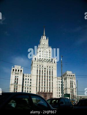 La tour du Ministère des Affaires étrangères de Russie à Moscou. Lumière directe du soleil, ciel bleu foncé. Un des gratte-ciel staliniens. Voitures sombres Banque D'Images