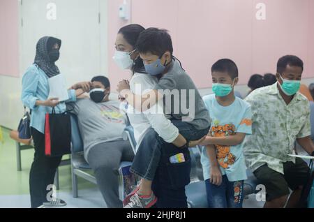 Bangkok, Thaïlande.31st janvier 2022.Mère vue porter son fils pour recevoir un vaccin contre le COVID-19.la Thaïlande a commencé à vacciner les enfants âgés de 5-11 ans pour prévenir la propagation du coronavirus COVID-19 à l'Institut national de la santé infantile de la Reine Sirikit à Bangkok.Crédit : SOPA Images Limited/Alamy Live News Banque D'Images