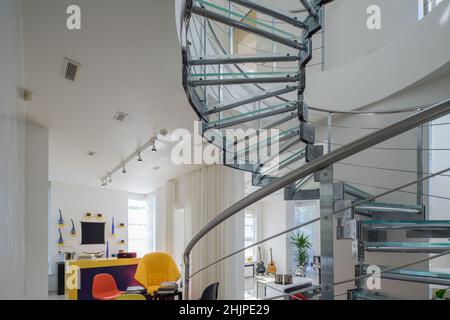 Moderne interiro de maison privée de luxe.Escalier en colimaçon en verre et en métal.Salon blanc. Banque D'Images