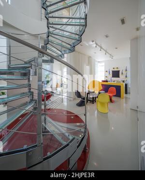 Moderne interiro de maison privée de luxe.Escalier en colimaçon en verre et en métal.Salon blanc. Banque D'Images