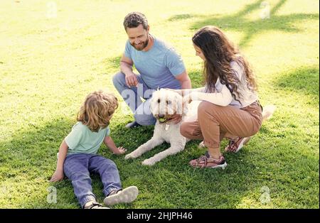 famille sympathique avec animaux. parents heureux avec un garçon d'enfant jouer avec le chien. Banque D'Images