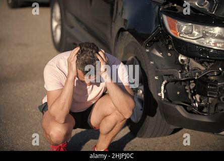 accident de voiture. conducteur frustré après un accident de la route. homme avec auto cassé sur la route. Banque D'Images