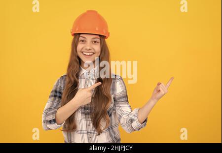 jeune fille dans un casque. enfant de constructeur dans une chemise à carreaux. concept de construction et de construction. Banque D'Images