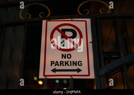 Panneau pas de parking sur une clôture en fer la nuit en gros plan Banque D'Images