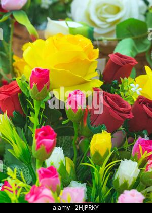 Beau bouquet roses fleur artificielle dans panier en osier vintage.Fleurs artificielles multicolores en tissu ou en tissu ressemblent à de vraies fleurs.Retour Banque D'Images