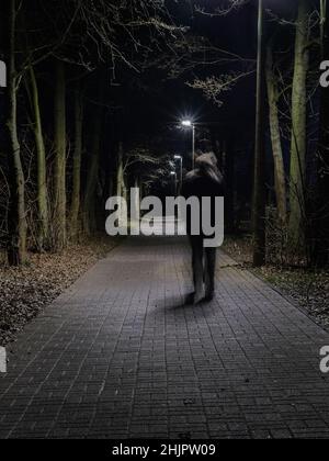 La personne en mouvement marche de façon inconfortable la nuit. Banque D'Images