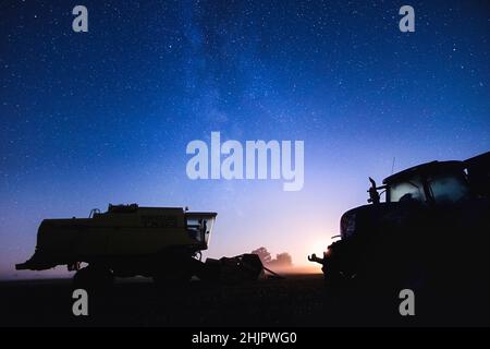 Moissonneuse-batteuse et tracteur de nuit avec ciel étoilé et lune de réglage  Norfolk UK Banque D'Images