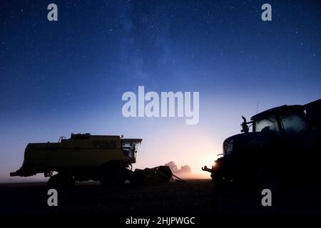 Moissonneuse-batteuse et tracteur de nuit avec ciel étoilé et lune de réglage  Norfolk UK Banque D'Images