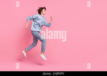 Photo pleine grandeur de la jeune femme impressionnée courir porter pull jeans chaussures isolées sur fond rose Banque D'Images