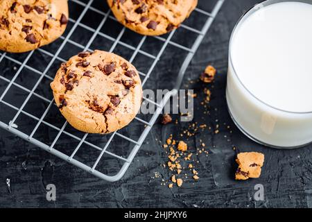Biscuits au chocolat avec noisettes et chapelure au chocolat avec verre de lait et verres en scène Banque D'Images