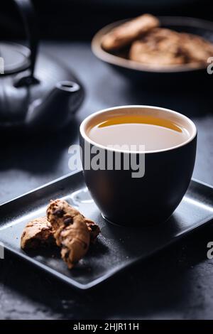 Biscuits aux pépites de thé et de chocolat sur différents arrière-plans et dans différentes tasses Banque D'Images
