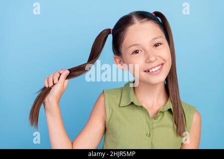 Photo de l'enfant d'école positif main tenir queue Toothy sourire isolé sur fond bleu de couleur Banque D'Images