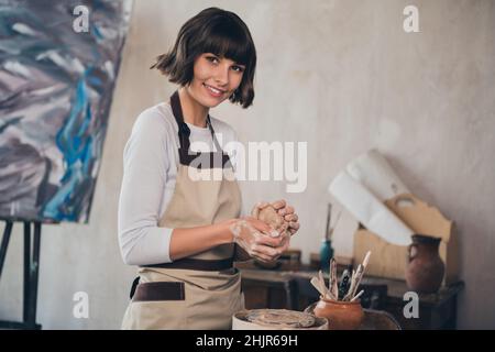 Photo d'un séminaire indépendant de dame potter professionnel faisant de la porcelaine d'art pot en faïence dans la salle de travail Banque D'Images