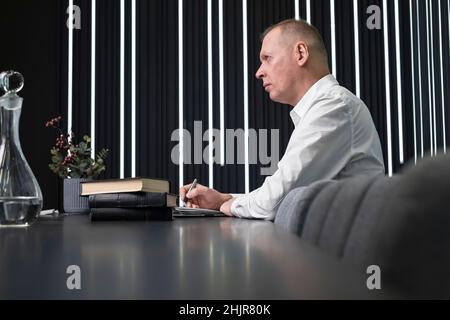 Homme d'affaires mature assis à la table de conférence.Homme confiant prenant part à la discussion d'entreprise ou de stratégie ou à la réunion.Concept de négociation et de partenariat.Photo de haute qualité Banque D'Images