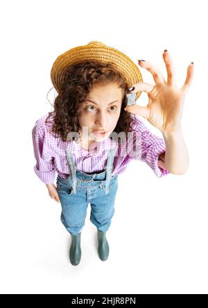 Vue en grand angle de la jeune fille, jardinière féminine en uniforme de travail et bottes de gommBoots isolées sur fond blanc.Concept de travail, d'émotions, d'agronomie Banque D'Images