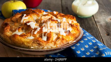 Pudding au pain.Petit-déjeuner anglais traditionnel avec pommes et sauce à la vanille.Pudding au pain et au beurre sur fond de bois ancien.Sélectif Banque D'Images