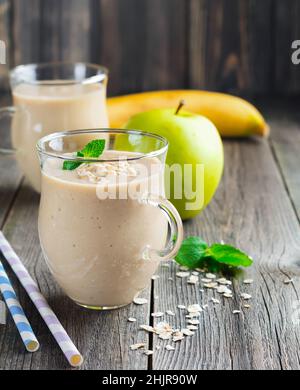 Smoothies.Smoothies aux pommes et aux bananes avec flocons d'avoine sur fond clair.Petit déjeuner sain.Mise au point sélective. Banque D'Images