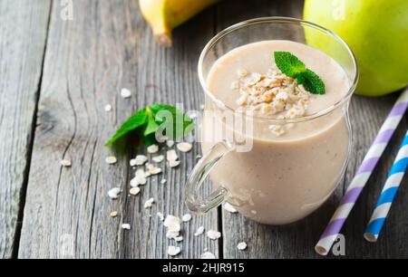 Smoothies.Smoothies aux pommes et aux bananes avec flocons d'avoine sur fond clair.Petit déjeuner sain.Mise au point sélective. Banque D'Images