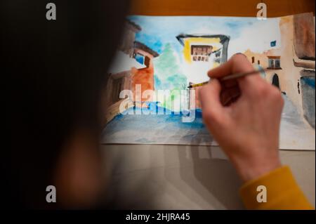 Atelier sur le processus de création artistique.Artiste peignant l'architecture colorée paysage urbain sur papier à l'aide de pinceau et d'aquarelles Banque D'Images