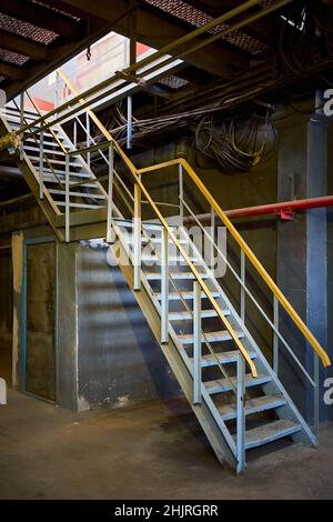 Fragment de structure de bâtiment industriel présentant des escaliers et des piliers métalliques.Image abstraite sur le sujet de l'architecture moderne, l'industrie et Banque D'Images