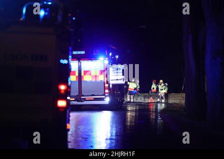 Storm Malik balaie la Suède samedi.Vents forts et vagues à Motala le samedi après-midi.Ici, le service de secours enlève les arbres soufflés de l'autre côté de la route au sud de Vadstena. Banque D'Images