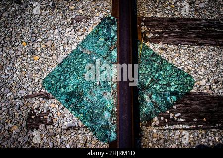 Une image très intéressante d'un panneau carré de verre qui a été nettoyé cassé au-dessus d'une voie de train.On dirait presque que la piste passe par elle. Banque D'Images
