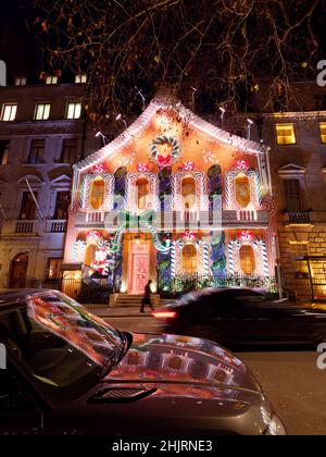 Londres, Grand Londres, Angleterre, janvier 4th 2022 : l'homme marche à côté du club privé Anabels avec sa façade de Noël Gingerbread House à Berkeley Square. Banque D'Images
