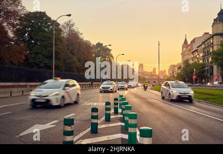 Taxis passant par la rue Alcala à côté du parc Retiro au coucher du soleil.Madrid.Espagne. Banque D'Images