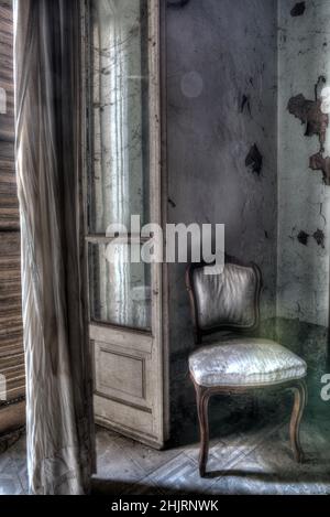 Italie, 20 janvier 2021. Vue sur une chambre avec un fauteuil et un mobilier anciens. Dans une maison abandonnée. Urbex Banque D'Images