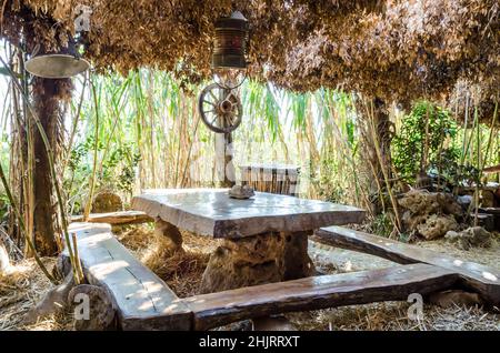 Magnifique bar d'été à thème avec canne en bambou et décoration en bois à Pula, Croatie. Table et banc traditionnels dans un environnement naturel. Banque D'Images