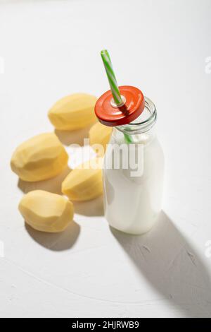Concept de lait de pomme de terre.Bouteille de lait de pomme de terre sur fond blanc.Une alternative aux produits animaux.Nourriture végétalienne. Banque D'Images