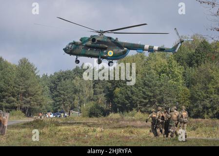 Des soldats ukrainiens et un hélicoptère ukrainien vus lors d'un exercice militaire conjoint Rapid Trident 2019 au Centre international pour le maintien de la paix et la sécurité de l'Académie nationale des forces terrestres près de Lviv. Banque D'Images