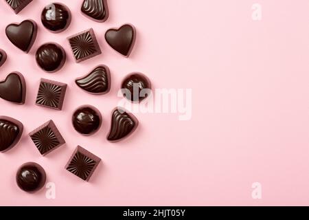 Assortiment de pralines au chocolat sur fond rose, plat, vue de dessus avec espace pour les copies Banque D'Images