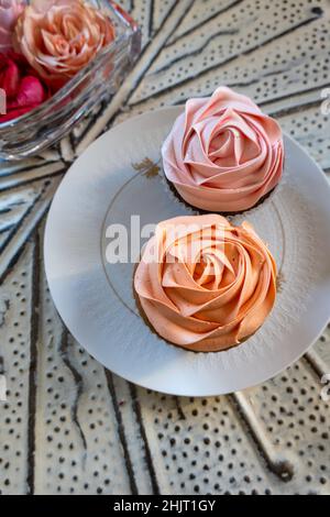 Des cupcakes roses élégants sur une assiette en porcelaine de marque, États-Unis Banque D'Images