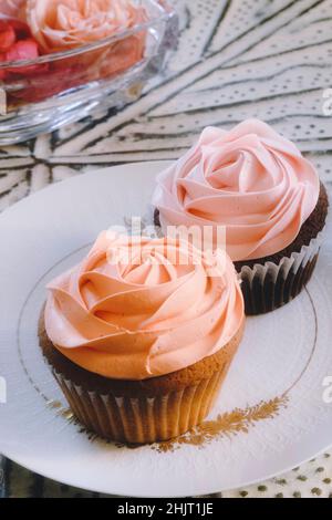 Des cupcakes roses élégants sur une assiette en porcelaine de marque, États-Unis Banque D'Images