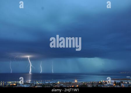 Tempête de nuit avec trois boulons éclairant frappant la mer Adriatique dans le golfe de Rijeka. Des éclairs spectaculaires sur une mer calme dans la baie de Rijeka, en Croatie Banque D'Images